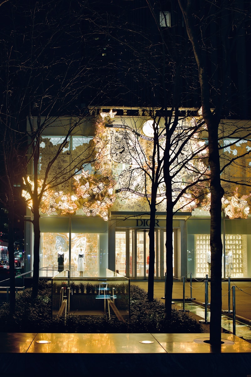 a building lit up at night with trees in front of it